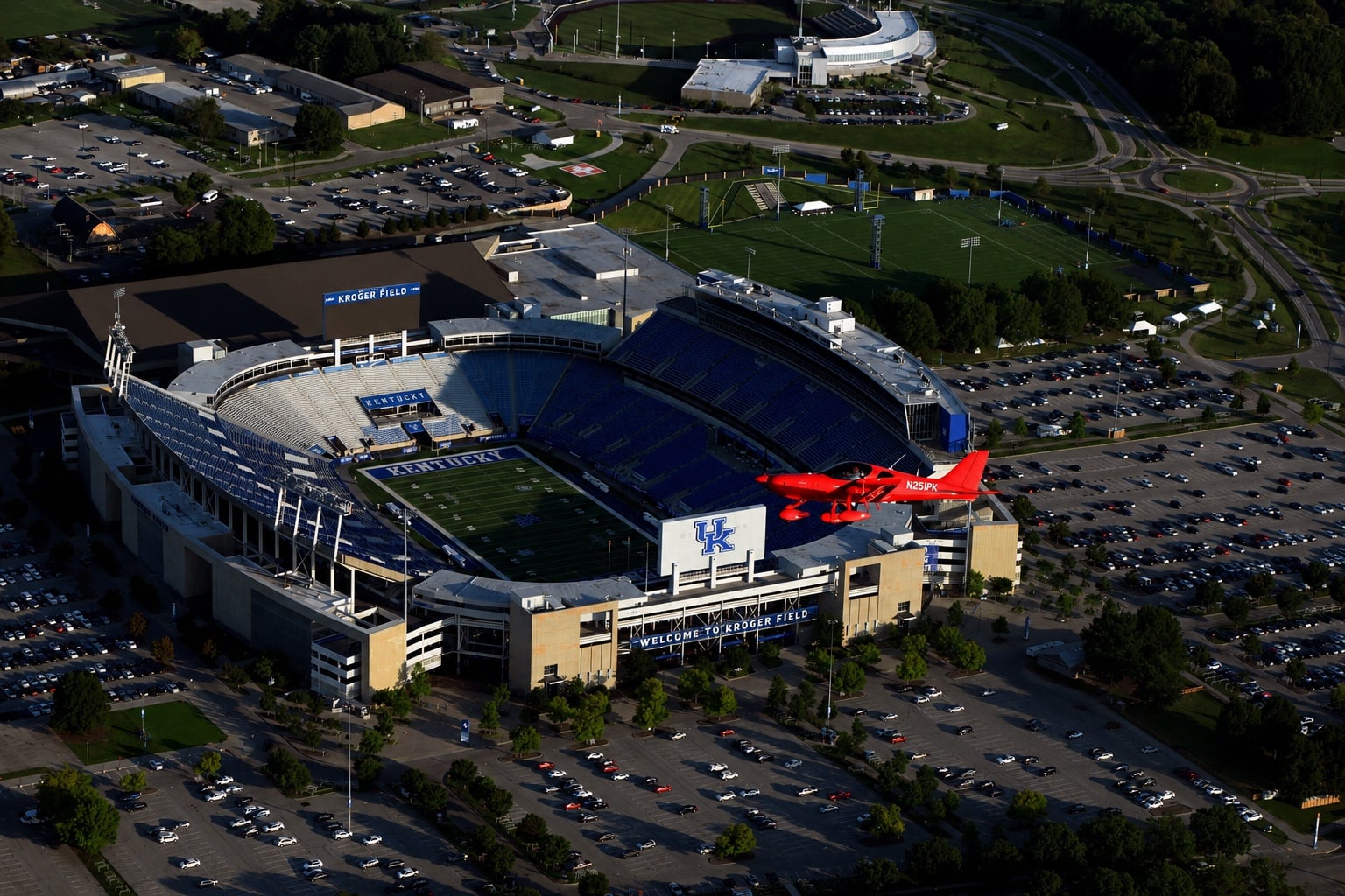 Red Bristell aircraft flying over Kroger Field in Lexington, Kentucky
